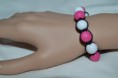 Bracelet ajustable sphères fuschia et blanc en résine sur cordon coton noir.